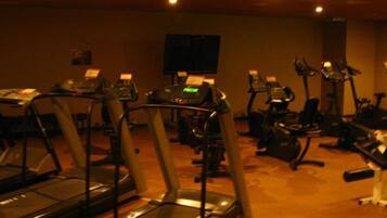 Et fitnesscenter med løbebånd, motionscykler og andet træningsudstyr.