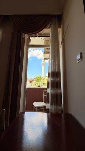 A room with a view of a mosque, a chair, and a table. - Ephesus Centrum (Selçuk)