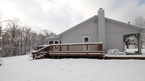 A two-story house with a covered porch and a wooden deck. - Comfortable lake living, pool access, 3 miles to marina (Monticello)