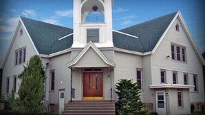 A large, single-story building with a central entrance, a bell tower, and a symmetrical facade. - Room For Everyone! Book The Incredible Belltower Suites, Sleeps 16! (St Clair)