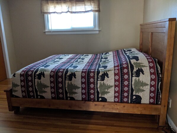 A single bed with a patterned bedspread, a window with blinds, and a wooden headboard. - Quiet, Comfortable Location! w/Double Garage
Easy access to WyoTech and UW (Laramie)