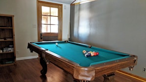 A pool table with balls, a wooden bookshelf, and a door with a window. - Quiet, Comfortable Location! w/Double Garage
Easy access to WyoTech and UW (Laramie)