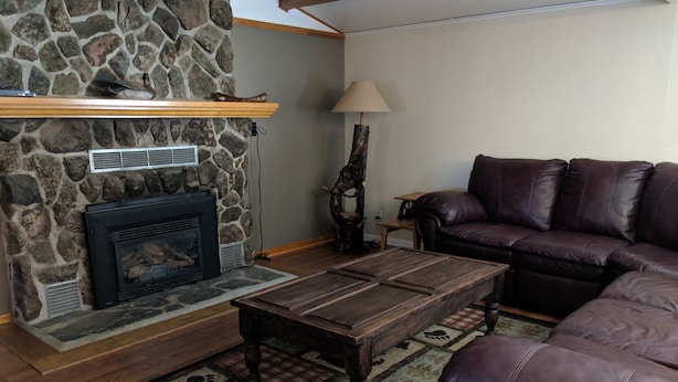A cozy living room with a stone fireplace, a leather sofa, and a wooden coffee table. - Quiet, Comfortable Location! w/Double Garage
Easy access to WyoTech and UW (Laramie)
