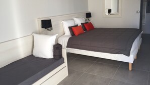 Ein Schlafzimmer mit Bett, Nachttisch, Lampe und Spiegel.