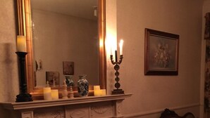 A cozy living room with a fireplace, a large mirror, and a sofa. - Susquehanna Manor Inn (Marietta)