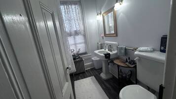 Un bagno con WC, lavandino e specchio.