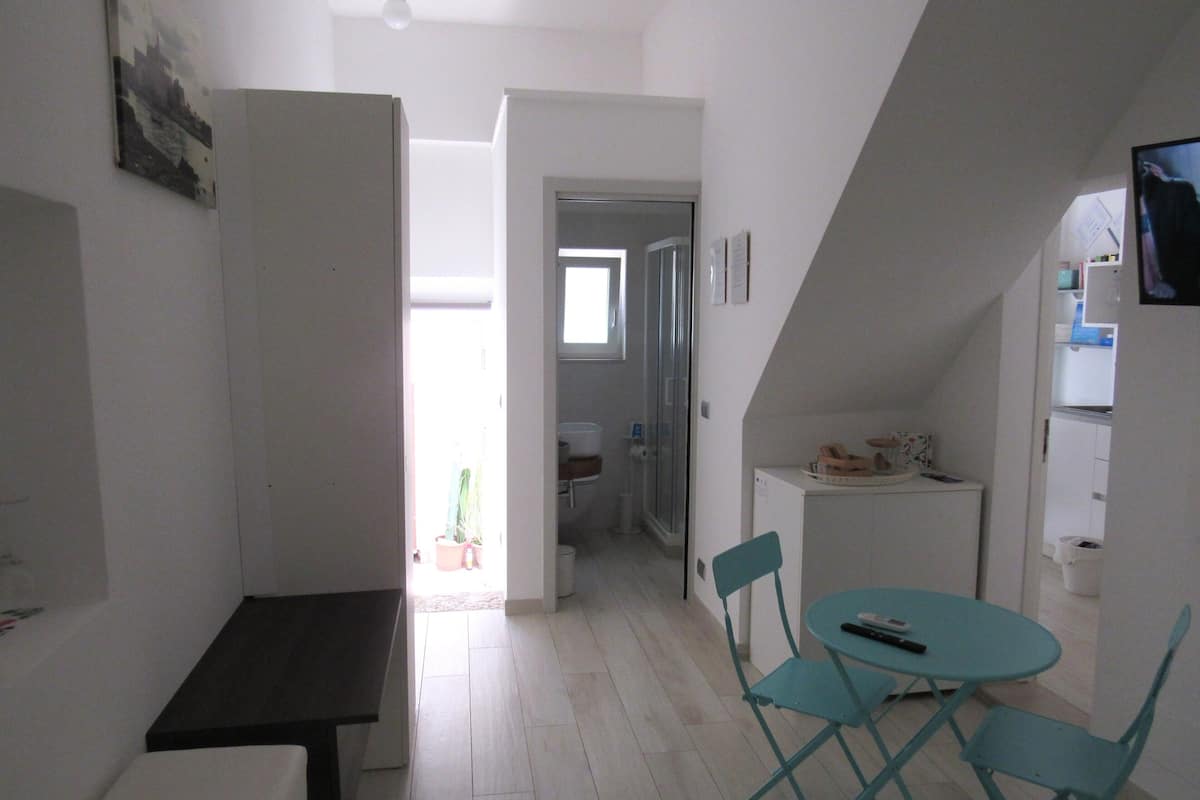 A compact kitchen with a dining area, a small table, and chairs.