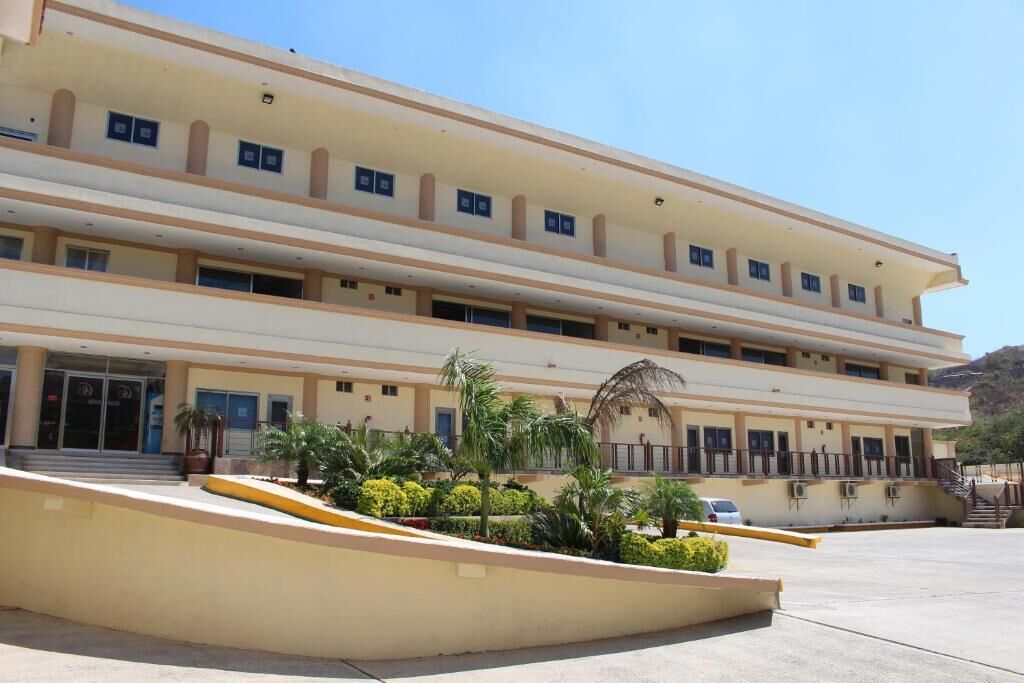 A multi-story building with a flat facade, large windows, and a central entrance with steps.