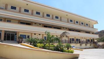 A multi-story building with a flat facade, large windows, and a central entrance with steps.