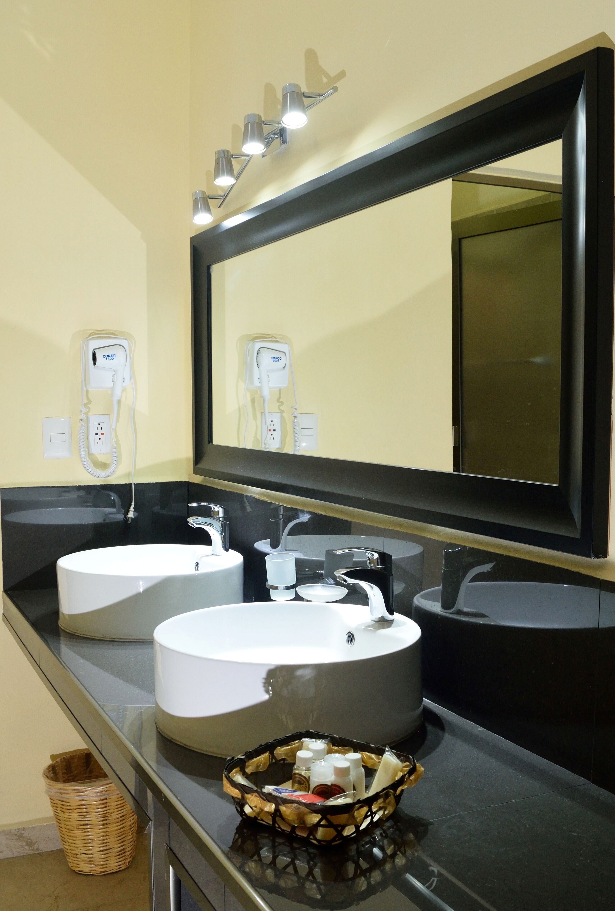 A bathroom with two sinks, a large mirror, and a telephone.