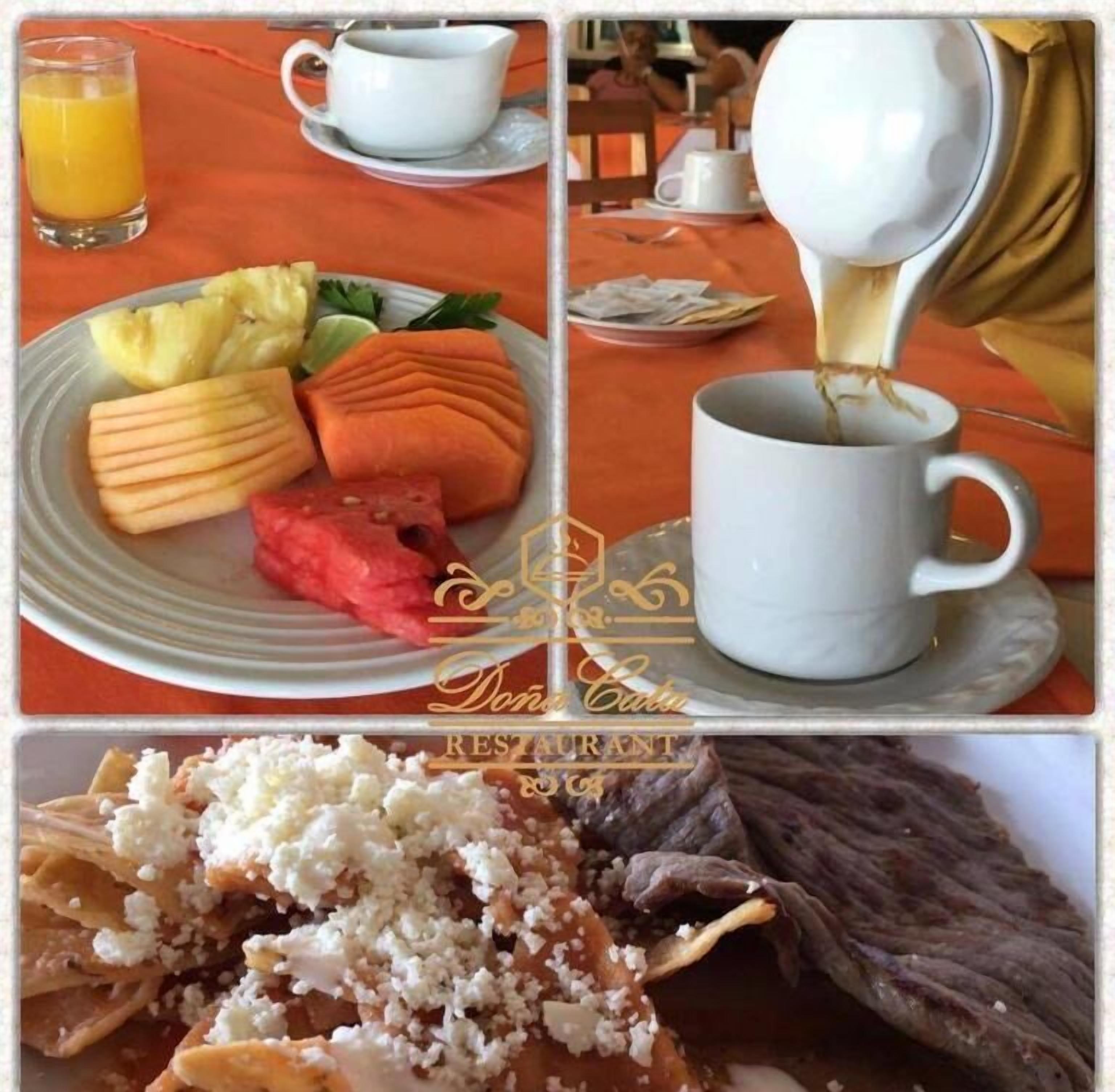 A breakfast setting with a plate of fruit, a cup of coffee, and a bowl of cereal.