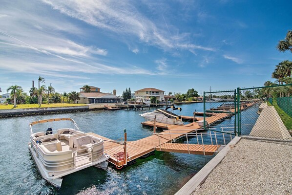 A marina with boats docked, a wooden dock, and a house in the background. - On-Site Beach Access! Waterfront Hudson Condo (Hudson)