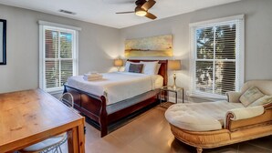 Ein Schlafzimmer mit einem hölzernen Bett, einem Deckenventilator und zwei Nachttischlampen.