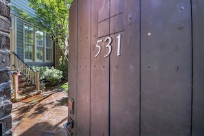 A wooden door with the number 531, a stone wall, and a staircase leading to a house with shutters. - Bright, Modern Carriage House off Crawford Square by Lucky Savannah (SAVANNAH)