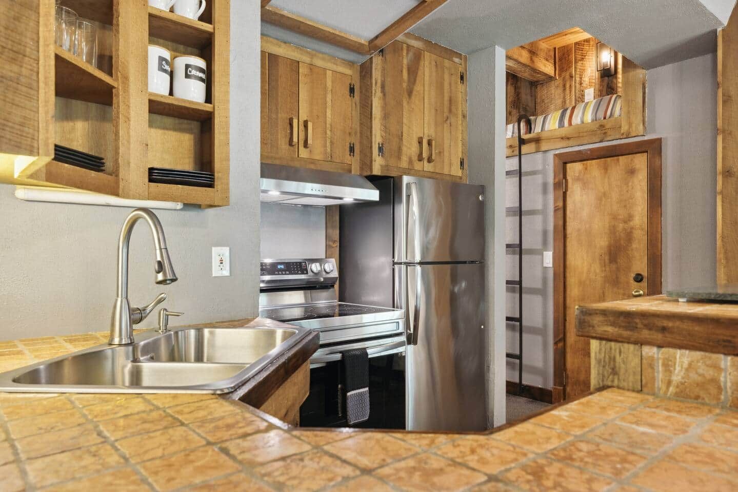A kitchen with wooden cabinets, stainless steel appliances, and a tiled backsplash.