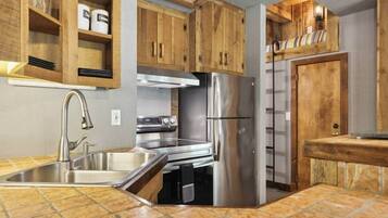A kitchen with wooden cabinets, stainless steel appliances, and a tiled backsplash.