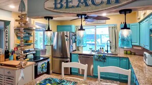 A kitchen with teal cabinets, a stainless steel refrigerator, and a hanging sign that reads "BEACH". - Piece of Paradise for All Seasons!!! Bring Your Boat! (St James City)