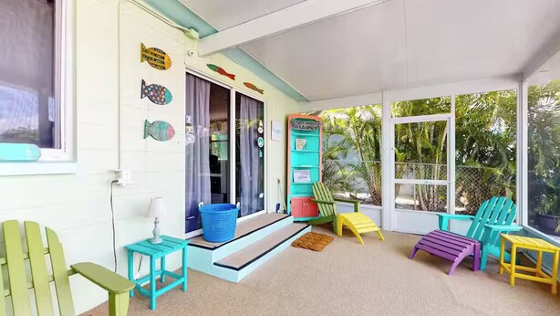 A bright, sunlit room with colorful chairs, a small table, and a fish-themed wall. - Piece of Paradise for All Seasons!!! Bring Your Boat! (St James City)