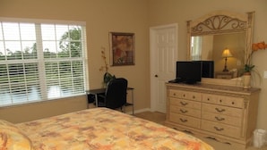 A bedroom with a bed, a desk, a dresser, a television, and a window with blinds. - 3 Bedroom Oakwater Resort Nearst Disney 3owt27ow33 (St. Cloud)