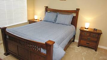 Quarto com cama de madeira, duas mesas de cabeceira e janela com persianas.