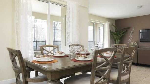 Un comedor con una mesa de madera dispuesta para cuatro personas, rodeada de sillas.