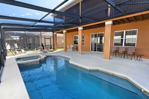Una piscina exterior techada con sillones de descanso y un área de terraza.