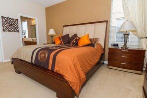 Une chambre à coucher avec un grand lit, une table de chevet avec une lampe, une commode et un miroir.