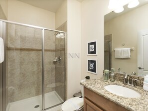 A bathroom with a glass-enclosed shower, a sink with a granite countertop, and a mirror above the sink. - Amazing 4 Bedrs Paradise Palms 4ppt30bp33 (Kissimmee)