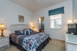 A bedroom with a bed, bedside lamps, a television, a window with curtains, and a picture on the wall. - 113bll Disney 5 Bedroom Pool Home With Games Room (Bartow)