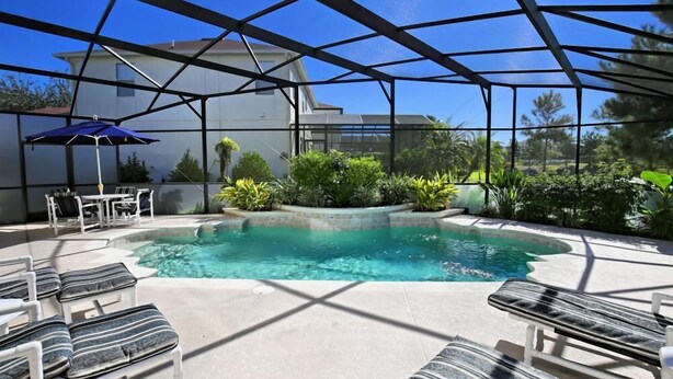 An indoor swimming pool with lounge chairs and a covered patio area. - 103bll Fantastic 4 bed With Games Room (Bartow)