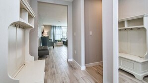 A hallway with a light-colored floor, white walls, and a built-in bench on the right. - 1203lr Beautiful Townhome Close TO Disney (Kissimmee)