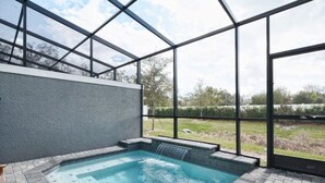 A hot tub area with a glass enclosure, a brick floor, and a view of the outdoors. - 1203lr Beautiful Townhome Close TO Disney (Kissimmee)