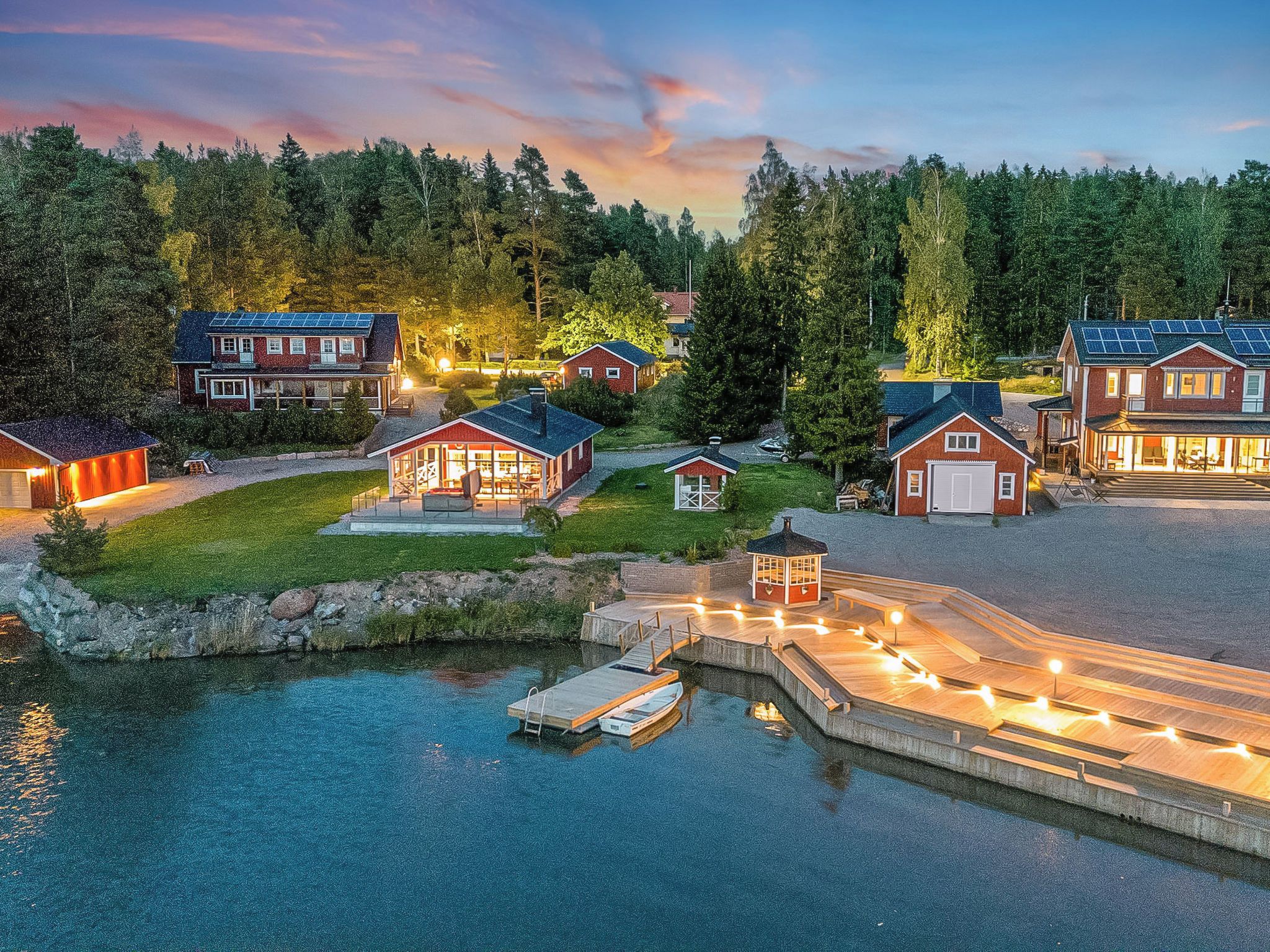 A waterfront property with multiple houses, a dock, and a small boat.