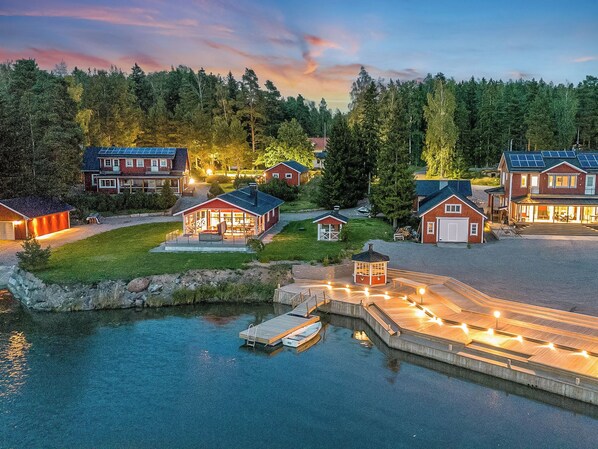 A waterfront property with multiple houses, a dock, and a small boat.