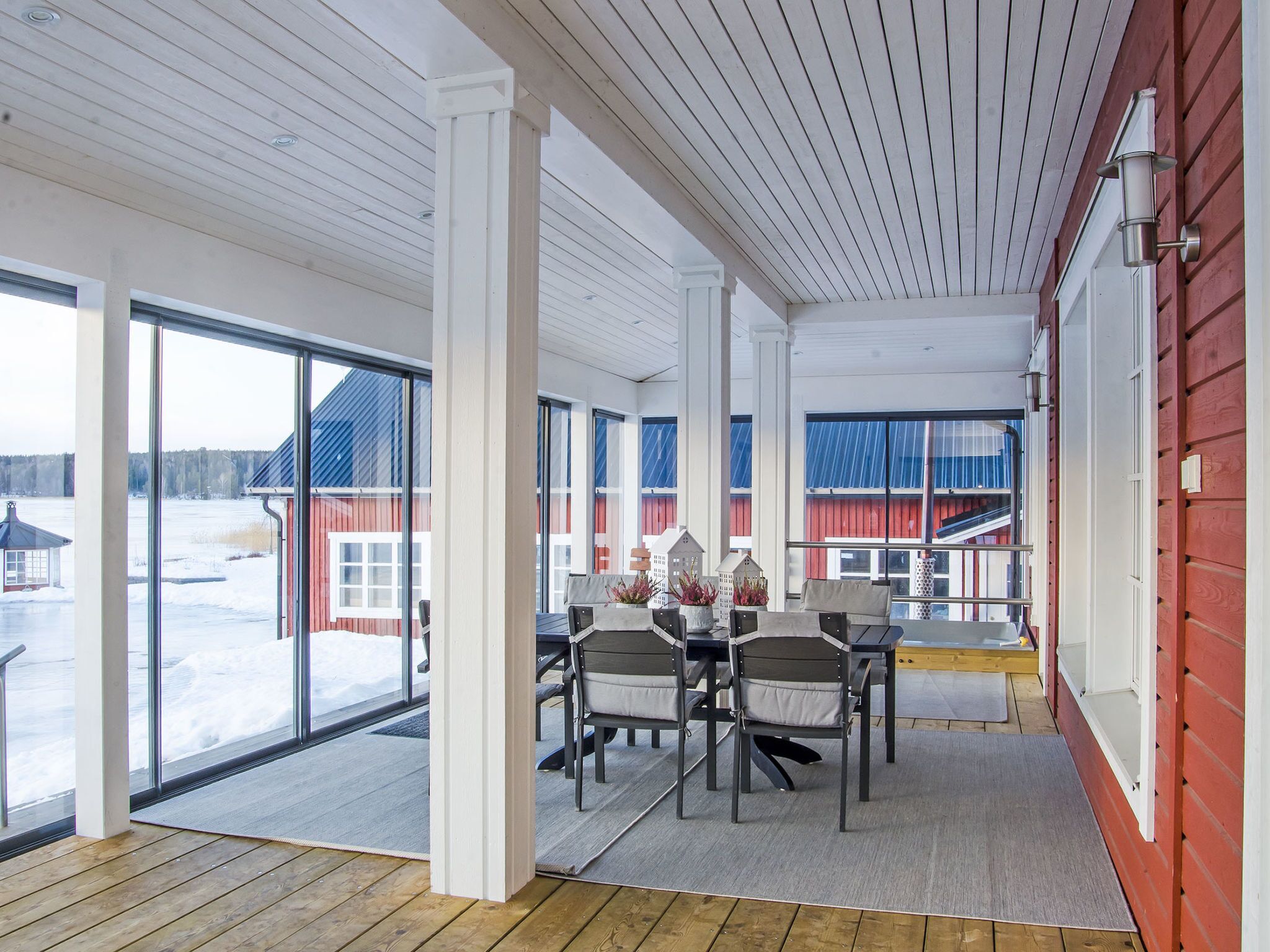 A spacious room with large windows, a wooden floor, and a table with chairs.