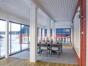 A spacious room with large windows, a wooden floor, and a table with chairs. - Villa eriksberg by Interhome (Porvoo)