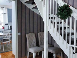 A staircase with white railings and a plant hanging on the right side.