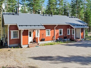 A two-story log cabin with a metal roof, a front porch, and a small attached garage. - Otsopirtti, maria by Interhome (Lieksa)