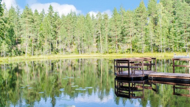 A tranquil lake with wooden docks and a dense forest in the background. - Otsopirtti, maria by Interhome (Lieksa)