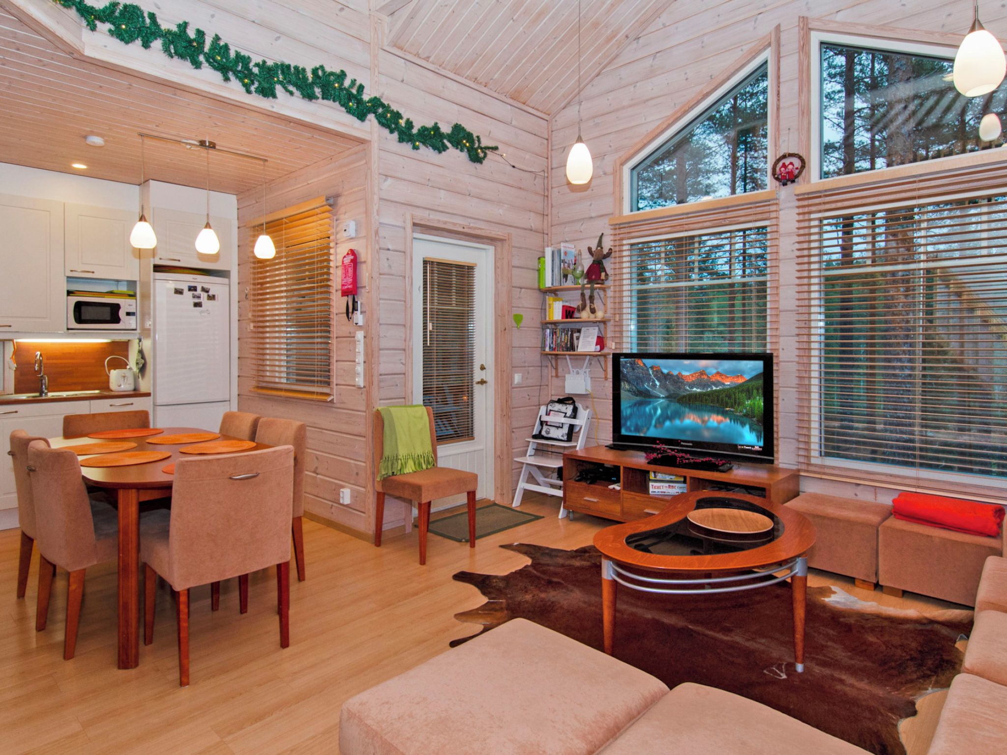 Ein gemütliches Interieur mit Essbereich, Sitzgelegenheiten, Fernseher und einer Küche.