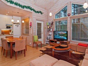 A cozy interior with a dining area, seating, a television, and a kitchen. - Otsopirtti, maria by Interhome (Lieksa)