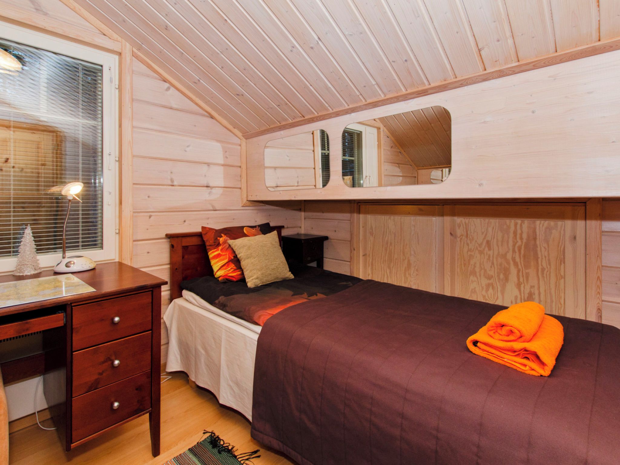 Habitación compacta con cama individual, escritorio y ventana.
