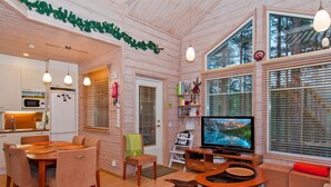 A cozy cabin interior with a dining area, a living room with a TV, and a kitchen. - Otsopirtti, maria by Interhome (Lieksa)