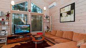 A cozy living room with a large TV, wooden walls, a leather rug, and a sofa. - Otsopirtti, maria by Interhome (Lieksa)