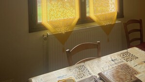 A room with a table set for dining, a radiator below the window, and a chair. - Maison Corisande, near the entrance to Bagnères de Bigorre (Gerde)
