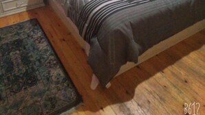 A bedroom with a bed, a nightstand, a wardrobe, and two framed pictures on the wall. - Very cozy and comfortable in a quite place (Heliopolis)