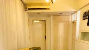 A living room with a green sofa, a white door, and a tiled floor. - Very cozy and comfortable in a quite place (Heliopolis)