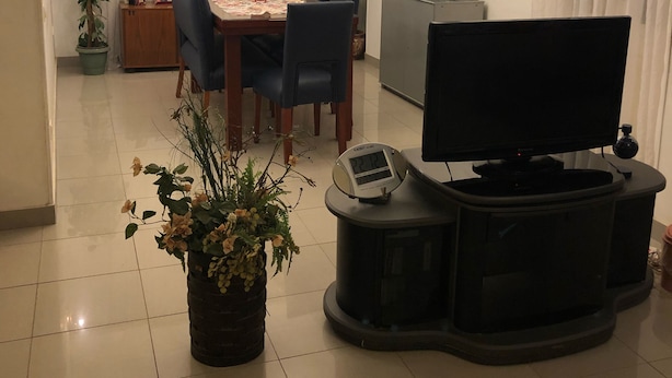 A modern living room with a dining area, a television, and a clock. - Very cozy and comfortable in a quite place (Heliopolis)