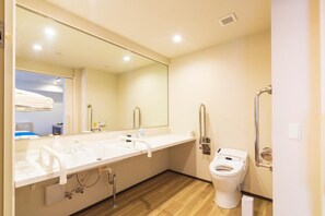 A modern bathroom with a long sink, a toilet, and a mirror. - Hotel Lantana Naha Kokusai - Dori (Naha)