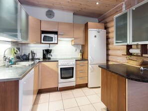 A modern kitchen with wooden cabinets, a microwave, a refrigerator, a stove, and a coffee maker.
